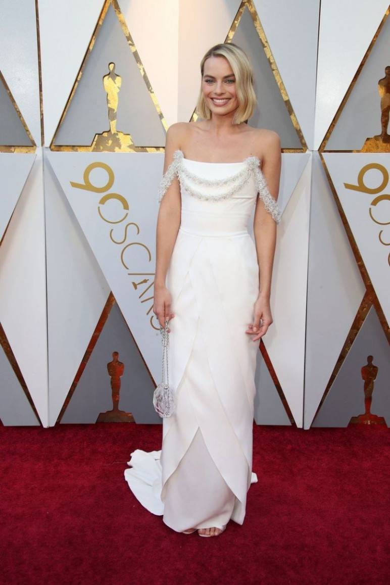 Margot Robbie is csatlakozott azokhoz a színésznőkhöz, akik fehérben vonultak fel a vörös szőnyegen, és jól tette, hiszen mesébe illő volt ebben a kreációban. A felsőrészen lévő különleges, leomló kiegészítő csak még inkább feldobta a megjelenést.
