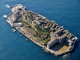 Hashima-sziget, Japán

Hashima szigete anno a világ legsűrűbben lakott települése volt, mára azonban teljesen elhagyatottá vált. A Japán délnyugati részén, Nagaszaki városához tartozó, a várostól mindössze 15 kilométerre található sziget csatahajó formájú, és hatalmas városfalak veszik körbe, amelyek a többméteres hullámoktól védik a Hashimát. A National Geographic adatai szerint a 20. század első felében több mint 5000 ember élt és dolgozott itt a tengeralatti szénbányászatnak köszönhetően. A betonfalakat a Mitsubishi cég találta ki, amikor 1890-ben felvásárolta a szigetet. A 160x480 méteres szigeten volt, amikor hektáronként 835 lakos élt. A város 1974-ig tele volt élettel: a széntermelés 1941-ben érte el csúcspontját, a szigeten pedig folyamatosan építették ki az infrastruktúrát. Rendőrség, óvoda, posta, szentélyek, mozi, üzletek, kórház és még szálloda is volt ekkoriban a szigeten, 1974-ben azonban a Mitsubishi bejelentette, hogy a szénbánya bezár, ezért pár hónapon belül minden lakos elhagyta a szigetet, munkalehetőségek híján. A szellemvárost a Skyfall című James Bond-film háttereként is szolgált.