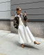 Leopárdmintás slingback cipő és légies midiszoknya

A leopárdmintás slingback cipők tökéletes választást jelentenek azok számára, akik egyszerre szeretnének elegáns, nőies és romantikus megjelenést. A nyitott sarokrész, a kényelmes pánt, a mandulaformájú orr és a visszafogott, széles sarok kifinomult összhatást teremt, miközben a leopárdminta egy csipetnyi merészséget visz a szettbe. Nem véletlen, hogy ezek a cipők a 2026-os nyári szezon egyik legkívánatosabb darabjai. A slingback fazon különösen jól működik könnyed, légies ruhadarabokkal. Egy hófehér összeállítás például tökéletes alapot biztosít a karakteres mintának: egy ráncolt derekú midiszoknya és egy hozzá illő, romantikus blúz egyszerre friss, nőies és rendkívül stílusos választás.